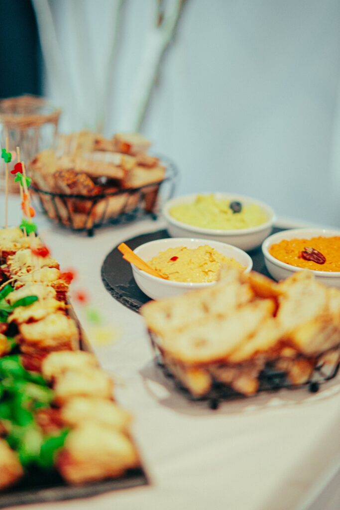 Close-up of a buffet table featuring dips, bread, and appetizers, offering a delicious culinary experience.